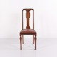 Dining chairs crafted in dark wood with turned legs and upholstered in high-quality red leather. ...