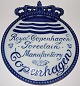 Royal 
Copenhagen 
Dealer 
sign/plate in 
English: Royal 
Copenhagen 
Porcelain 
Manufactory. In 
...