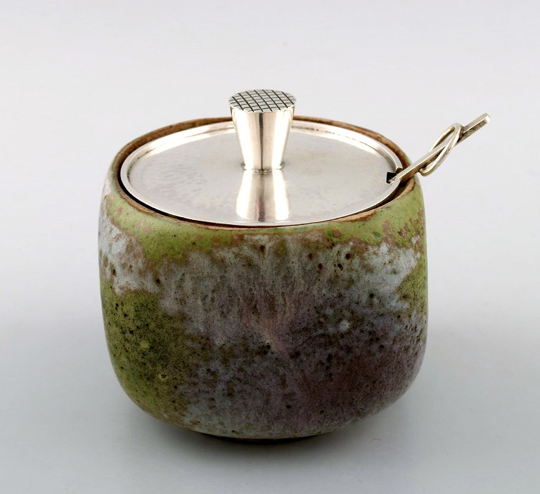 Hans Hansen (1884-1940) and Bode Willumsen (1895-1987).
Unique jam jar of blue-green glazed stoneware, decorated with lid
and Hans Hansen jam spoon in hammered sterling silver.