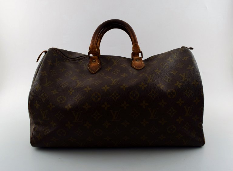 Louis Vuitton: Taske af monogram kanvas med to læderhanke, lyse 
læderbesætninger, messingbeslag, lynlåsrum. Original lås med nøgle.
Ca. 1960.