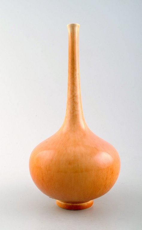 Scandinavian ceramist. Unique ceramic vase with narrow neck in yellow tones.