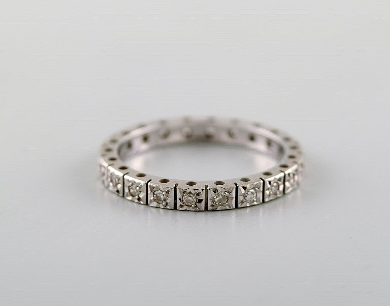Modernistisk ring i 14 karat hvidguld med talrige diamanter. 
