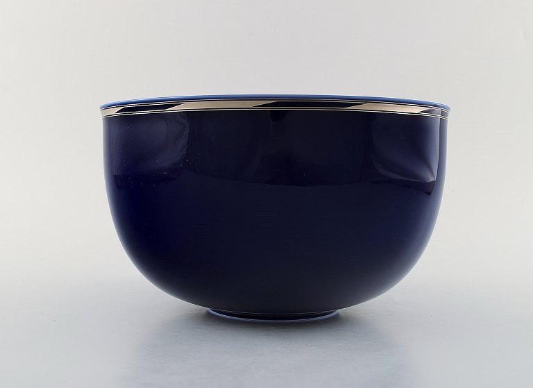 Alev Siesbye for Royal Copenhagen. Bowl of porcelain decorated with blue glaze 
and border decorated with gold.
1980
