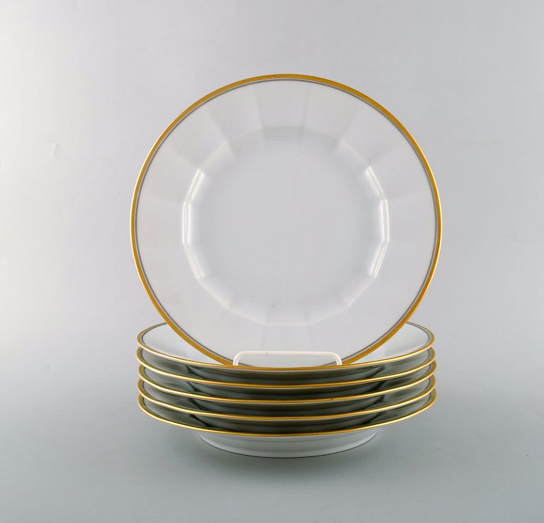 Royal Copenhagen. Seks middagstallerkener i porcelæn med guldkant. 
