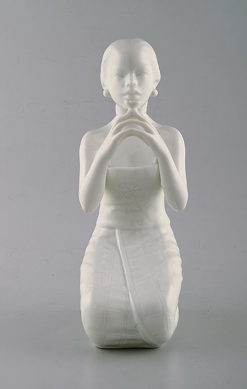 Harald Salomon for Rörstrand, hvidglaseret figur forestillende balineser 
holdende blomst i hånden.