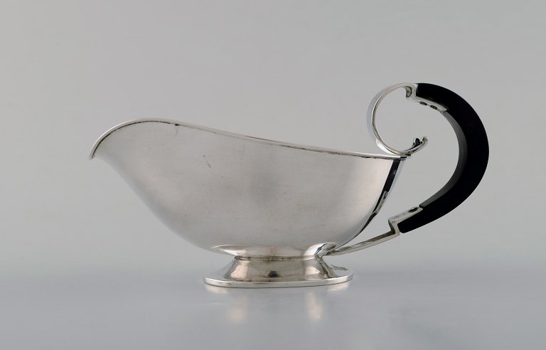 Danish silversmith. Art deco sauce boat in silver (830) with ebony handle. Dated 
1936.
