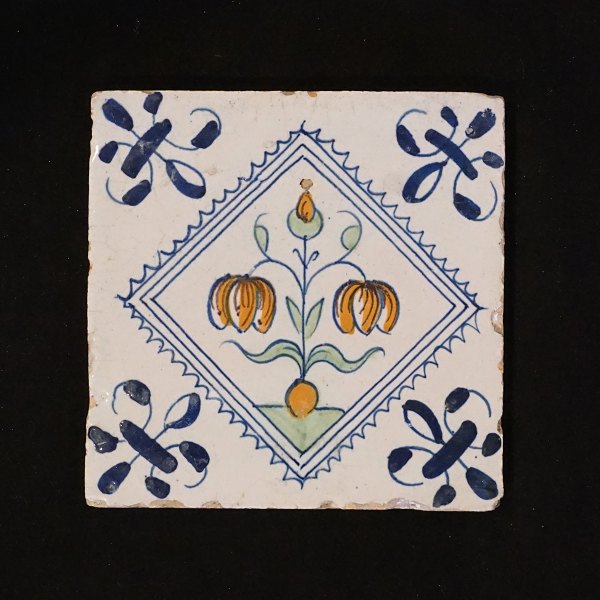 Polychromdekorierte holländische Fliese mit Blumenmotiv. Um 1620-40. Grösse: 
13x13cm