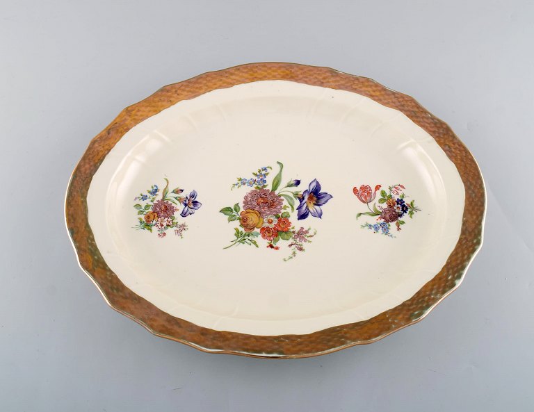 Royal Copenhagen serveringsfad i porcelæn med blomstermotiver og guldkant. Midt 
1900-tallet.
