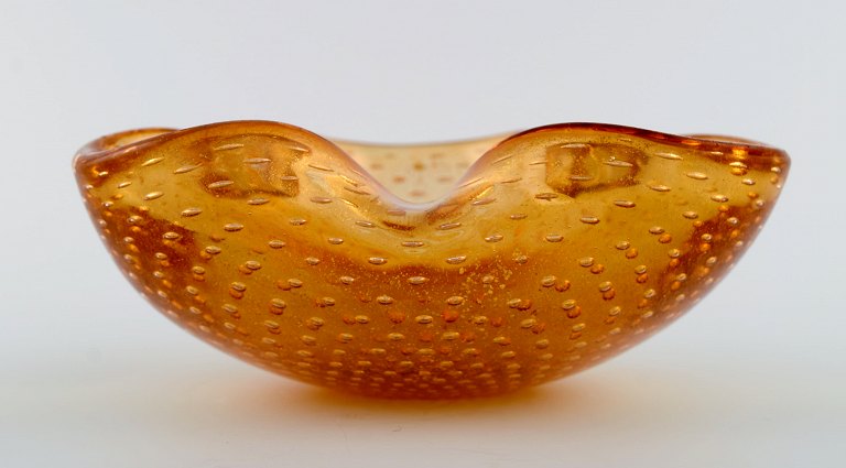 Murano bowl in amber colored mouth-blown art glass with inlaid air bubbles. 
Italian design, 1960