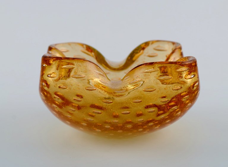 Murano bowl in amber colored mouth-blown art glass with inlaid air bubbles. 
Italian design, 1960