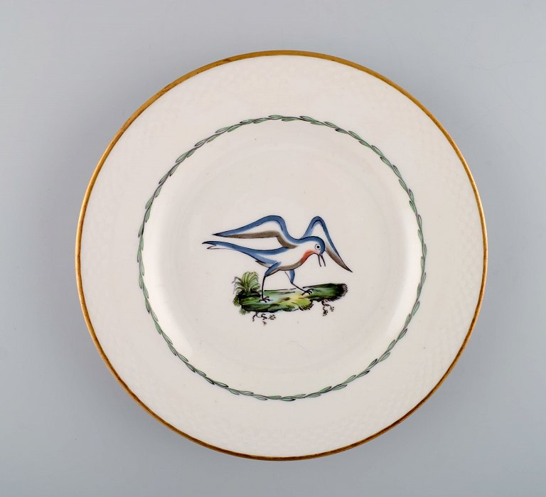 Royal Copenhagen frokosttallerken i håndmalet porcelæn med fuglemotiver og 
gulddekoration. Tidligt 1900-tallet. Fire stk på lager. 
