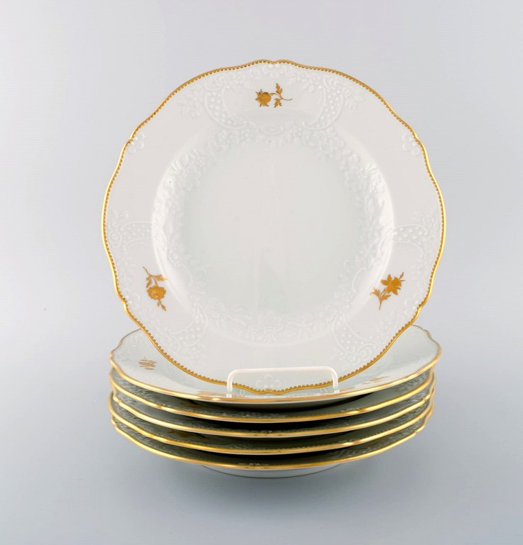 Six Meissen porcelain dinner plates with flowers and foliage in relief and gold 
decoration. 20th century.
