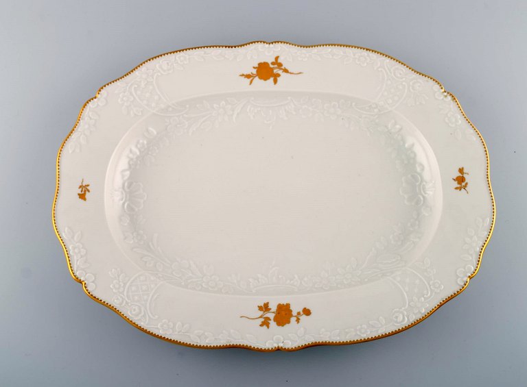 Large Meissen serving dish in porcelain with flowers and foliage in relief and 
gold decoration. 20th century.
