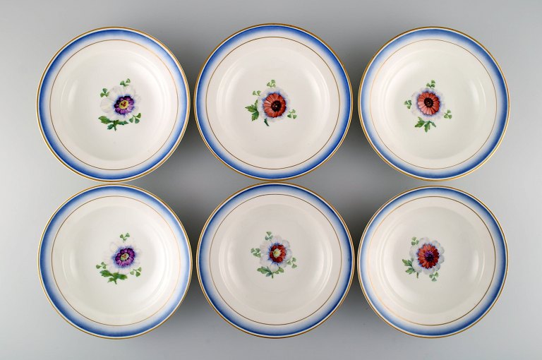 Seks antikke Royal Copenhagen dybe tallerkener i håndmalet porcelæn med blomster 
og blå kant med guld. Modelnummer 592/9050. Sent 1800-tallet. 
