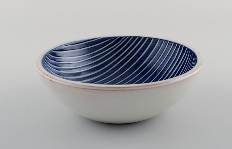 Ingrid Atterberg for Uppsala Ekeby. Bowl in glazed stoneware. Striped design in 
shades of blue and white. Dated 1947-53.
