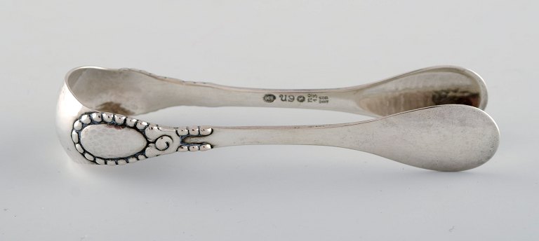 Evald Nielsen number 13 sugar tong in hammered silver (830). Dated 1925.
