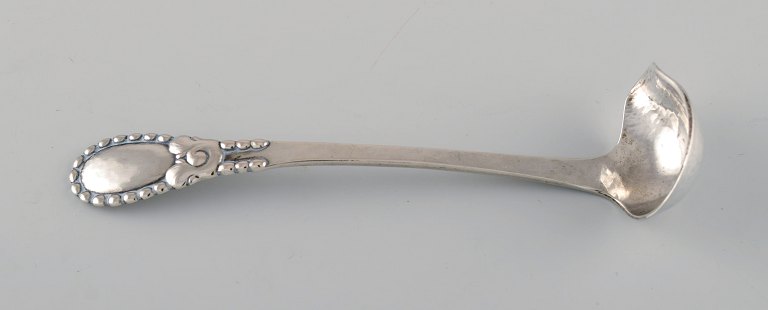 Evald Nielsen nummer 13 smørsauce ske i hammerslået sølv (830). Dateret 1924. 
