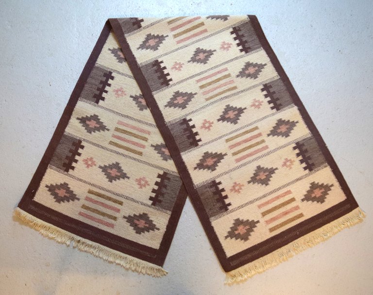 Swedish textile designer. Long hand-woven RÖLAKAN carpet with geometric fields 
in brown, pink and cream shades. Mid-20th century.

