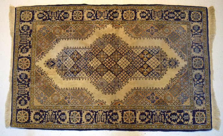 Håndvævet persisk tæppe i klassisk stil. Brune, grønne og blå nuancer. Midt 
1900-tallet.
