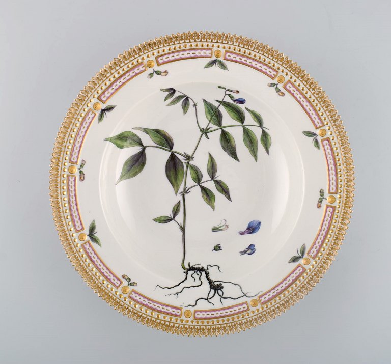 Royal Copenhagen flora danica dyb tallerken i porcelæn med håndmalede blomster 
og gulddekoration. Tidligt 1900-tallet.
