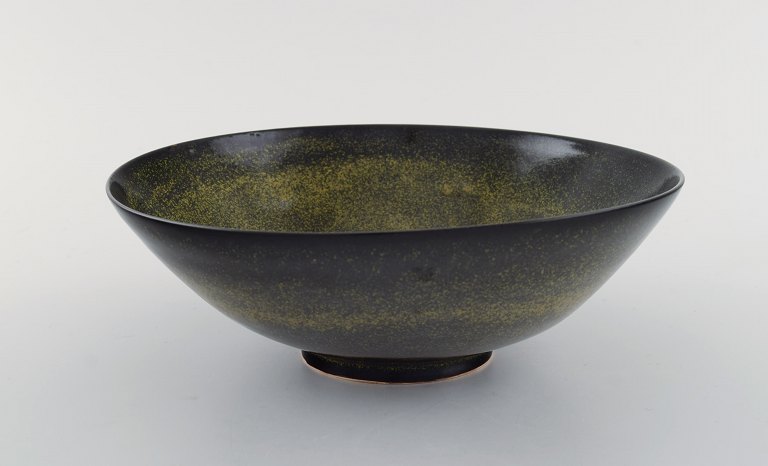 Gunnar Hartman (b. 1949), Sweden. Bowl on foot in glazed ceramics. Beautiful 
black glaze with yellow touches. Late 20th century.
