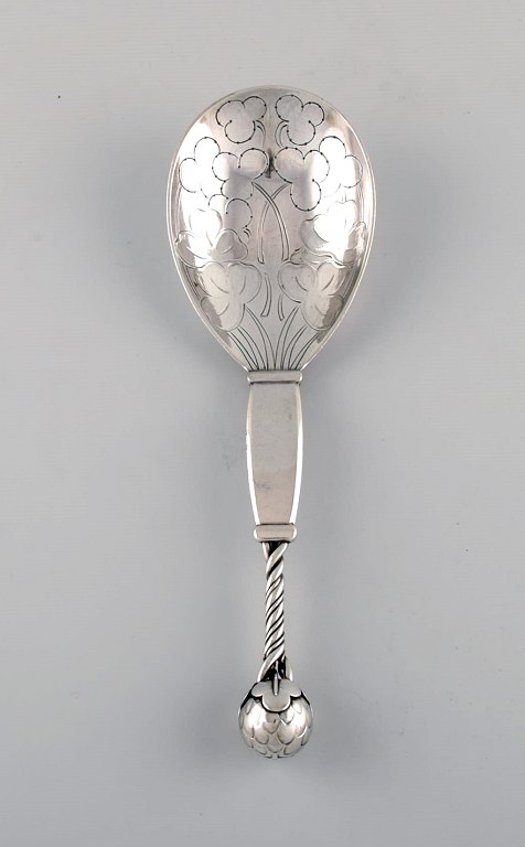 Rare Georg Jensen strawberry spoon in sterling silver designed with openwork 
head and partially twisted handle, knob made with stylized foliage and 
strawberries, dess. 35.
