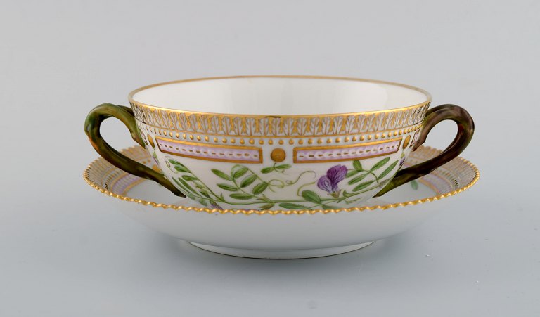 Royal Copenhagen Flora Danica boullionkop med underkop i håndmalet porcelæn med 
grenformede hanke, blomster og gulddekoration. Modelnummer 20/3612.  
