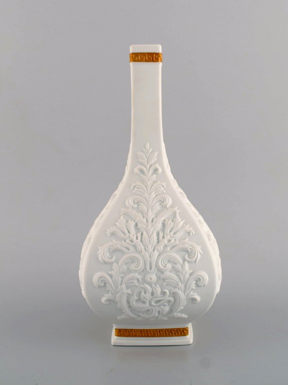 Gianni Versace for Rosenthal. White Baroque vase in white ceramics with foliage 
in relief and gold decoration. Late 20th century.
