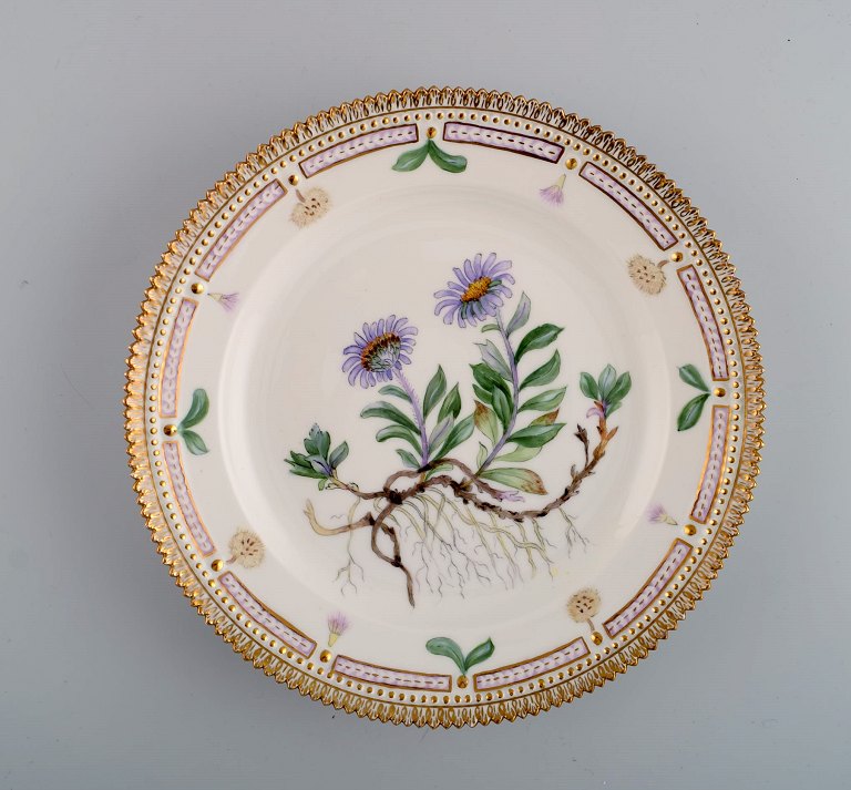 Royal Copenhagen Flora Danica tallerken i håndmalet porcelæn med blomster og 
gulddekoration. Dateret 1952.
