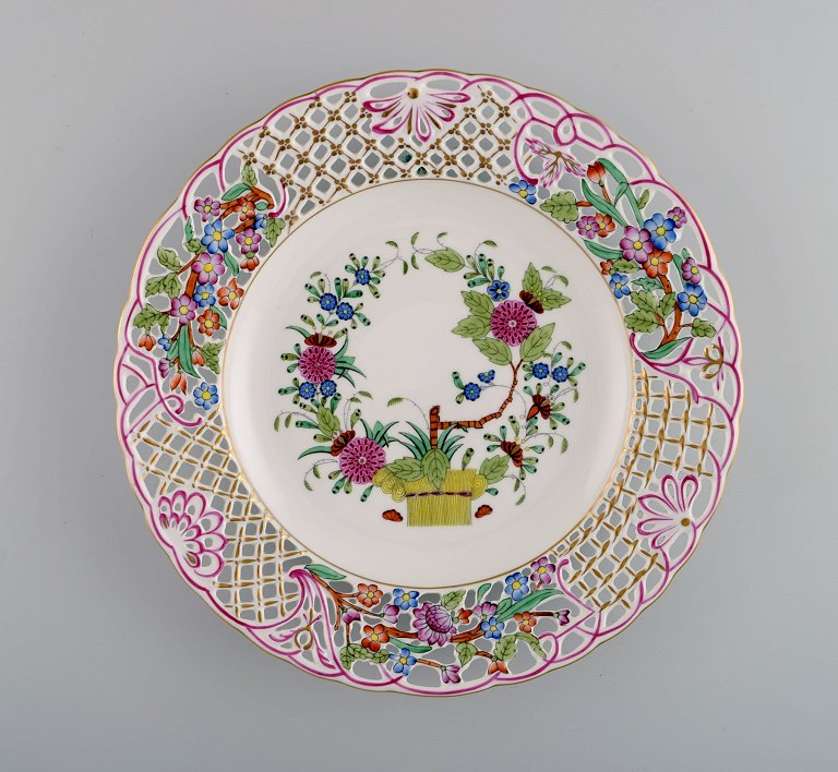 Herend dinner plate in openwork porcelain with hand-painted flowers and gold 
decoration. Mid-20th century.
