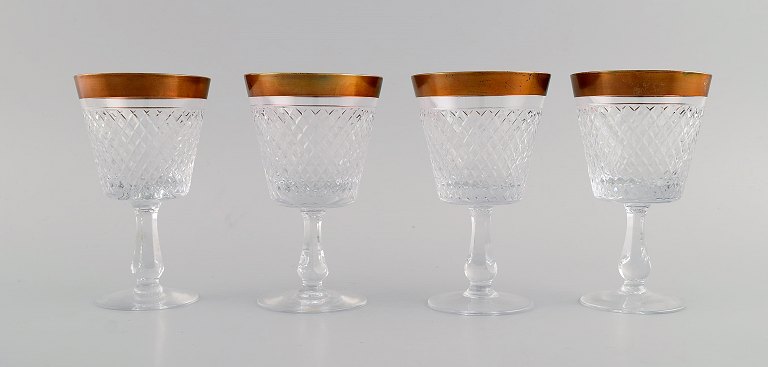 Four wine glasses in mouth-blown crystal glass with gold edge. France, 1930s.
