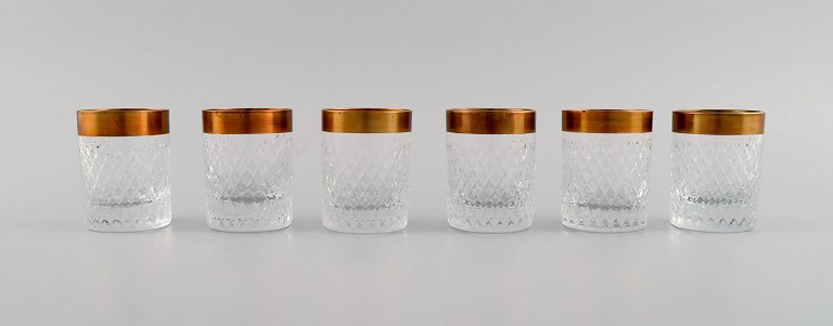 Seks vodka/snapsebægre i mundblæst krystalglas med guldkant. Frankrig, 
1930
