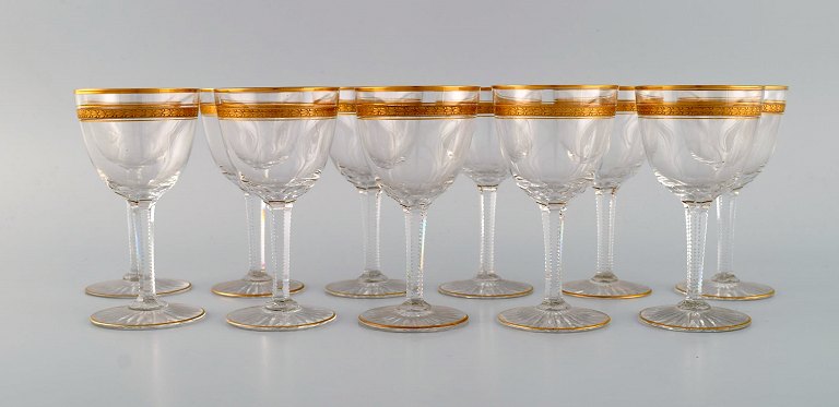 Baccarat, France. 11 art deco white wine glasses in mouth-blown crystal glass 
with gold decoration in the form of leaves. 1930s.
