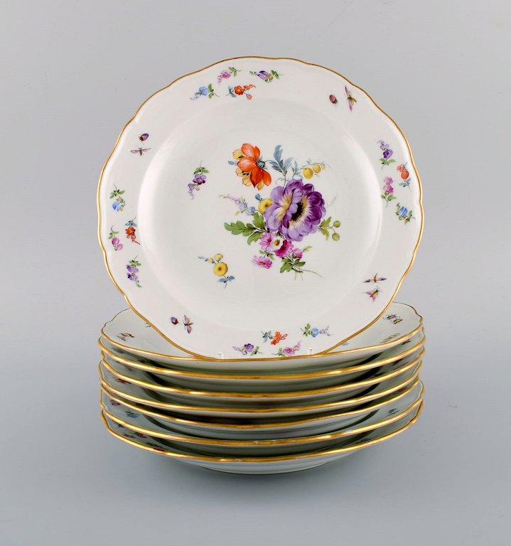 Otte antikke Meissen tallerkener i porcelæn med håndmalede blomster og guldkant. 
Ca. 1900.
