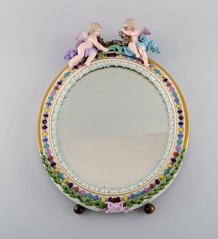 Antique Meissen porcelain mirror with original glass. Decorated with angels and 
repousse flowers. Approx. 1900.
