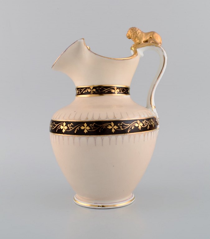 Antik Altwasser chokoladekande i porcelæn modeleret med løve på hanken. 
Håndmalede blomster og gulddekoration. Sent 1800-tallet.
