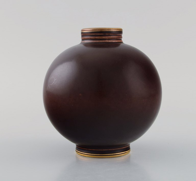 Art deco Rörstrand vase in glazed ceramics. Beautiful ox blood glaze and 
hand-painted gold decoration. Mid-20th century.
