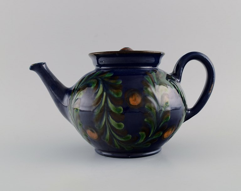 Kähler, HAK. Large teapot in glazed ceramics. Flowers and foliage on a dark blue 
background. 1930s / 40s.
