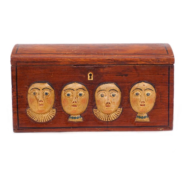 An early 19th century original decorated wooden box with wood cut faces. Denmark 
circa 1800. H: 14cm. L: 26cm. D: 13cm