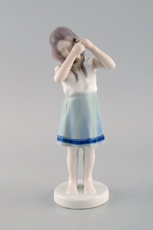 Rare Bing & Grøndahl porcelain figurine. Girl braids her hair. Model number 
1758. Early 20th century.
