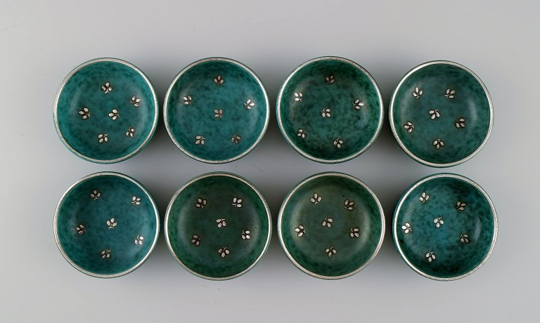 Wilhelm Kåge (1889-1960) for Gustavsberg. Eight small Argenta bowls in glazed 
ceramics. Beautiful glaze in shades of green with silver inlay in the form of 
leaves. Mid 20th century.
