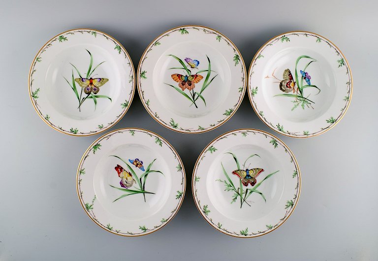 Five antique Royal Copenhagen deep plates in porcelain with hand-painted 
flowers, butterflies and gold edge. Mid-19th century.
