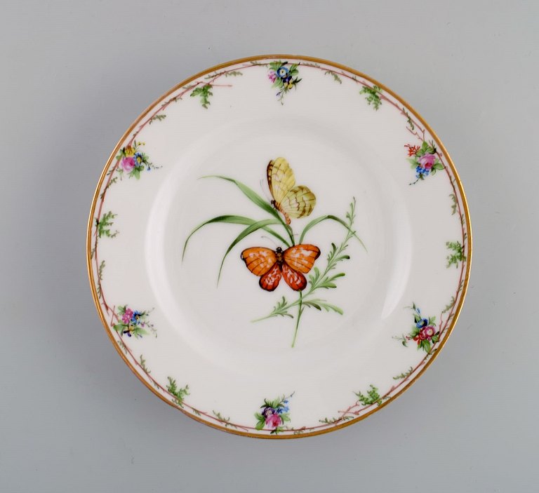Antik Royal Copenhagen tallerken i porcelæn med håndmalede blomster, sommerfugle 
og guldkant. Midt 1800-tallet.
