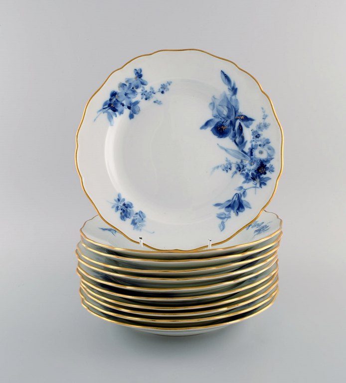 11 antikke Meissen middagstallerkener i håndmalet porcelæn. Blå blomster og 
guldkant. Tidligt 1900-tallet.
