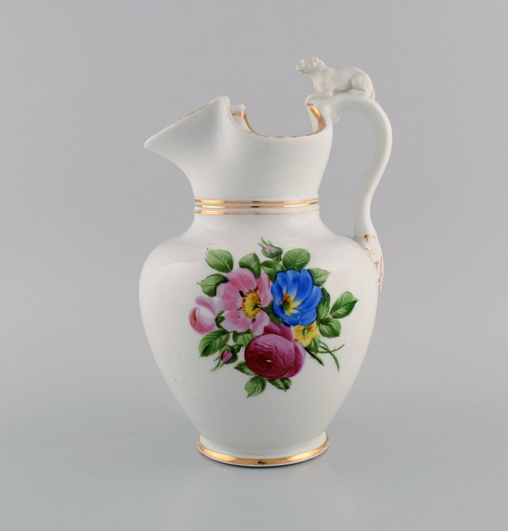 Antique Bing & Grøndahl chocolate jug in porcelain modeled with a lion on the 
handle. Hand-painted flowers and gold decoration. 1870s.
