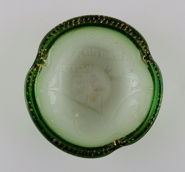 Daum Nancy, France. Art nouveau bowl in green mouth blown art glass. Embossed flowers and hand-painted gold decoration. Approx. 1900.