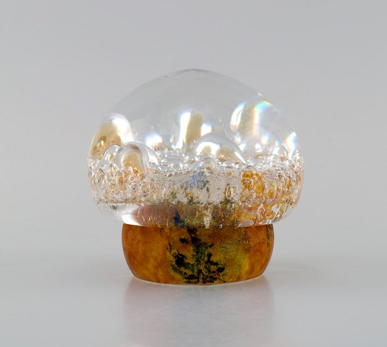 Göran Wärff for Kosta Boda. Paper weight shaped as a mushroom in amber colored 
and clear mouth-blown art glass with inlaid bubbles. Swedish design, 1970s.
