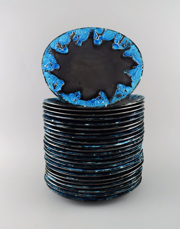 Fransk keramiker. 24 middagstallerkener i glaseret stentøj. Smuk glasur i 
azurblå nuancer. Unika keramik af høj kvalitet. Midt 1900-tallet. 
