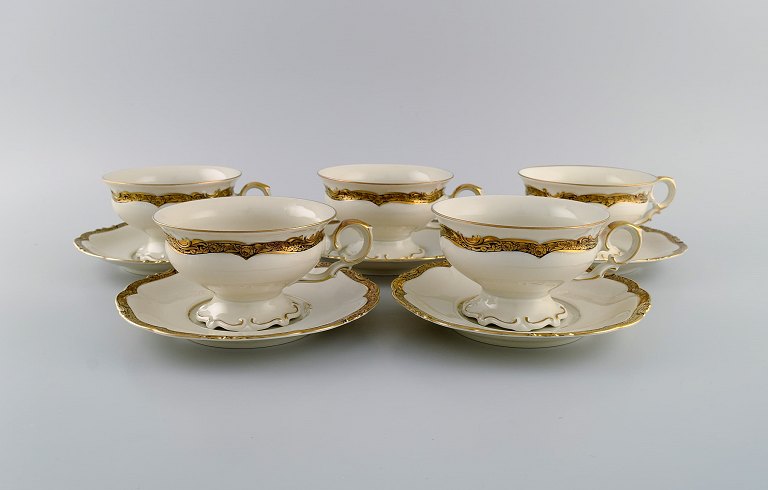 KPM, Berlin. Fem Royal Ivory tekopper med underkopper i cremefarvet porcelæn med 
gulddekoration. 1920