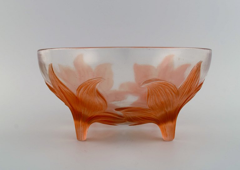 René Lalique (1860-1945), Frankrig. Sjælden "Lys" skål på fødder i klart og 
orange mundblæst kunstglas med fire liljer. 1920